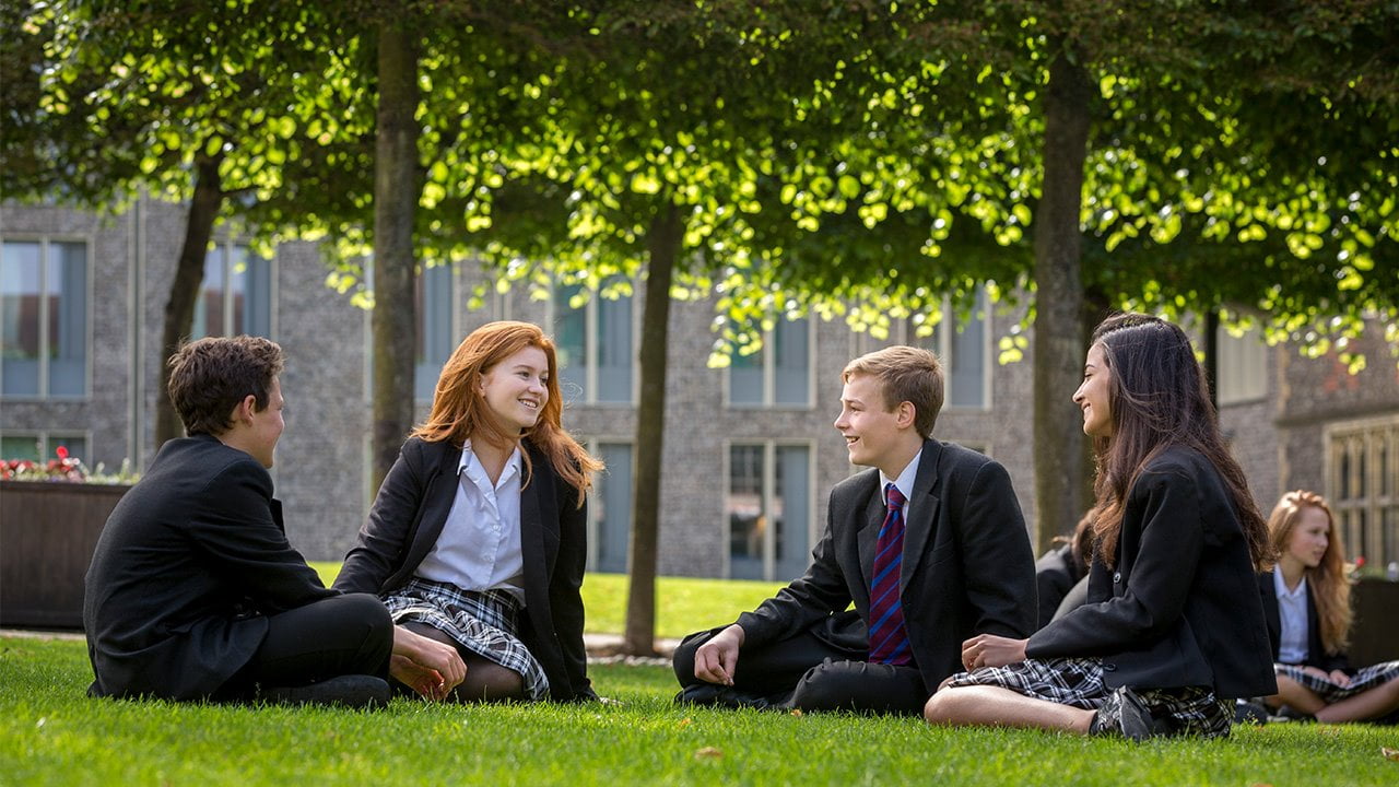 Brighton College Co Ed Pupils Sitting On Grass