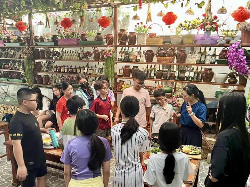 Engaging in a lively cooking challenge, they navigated bustling markets, transforming ingredients into a delicious traditional spread for their classmates. 
